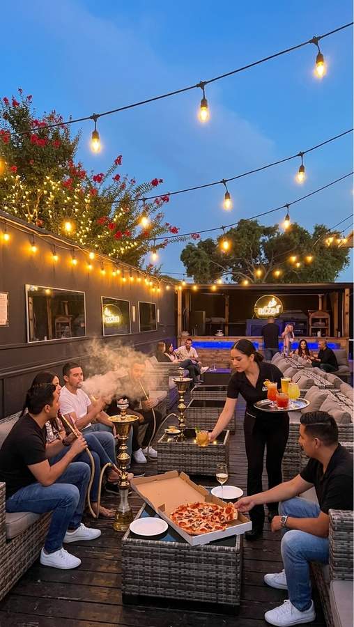 Guests enjoying hookah and pizza at Dream Lounge